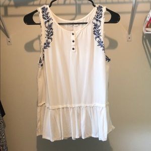 White peplum top with blue embroidery detail